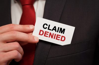 Businessman putting a card with text Claim Denied in the pocket